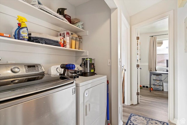 laundry area with washer and dryer, laundry area, and light wood-type flooring