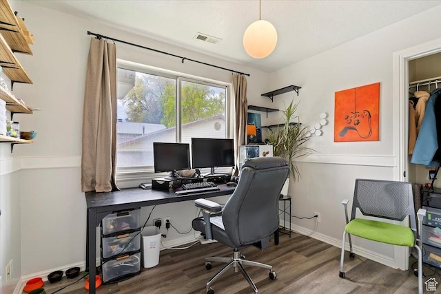 office area with baseboards, wood finished floors, and visible vents