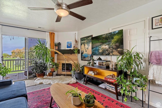 living room with visible vents, a ceiling fan, a textured ceiling, and carpet floors