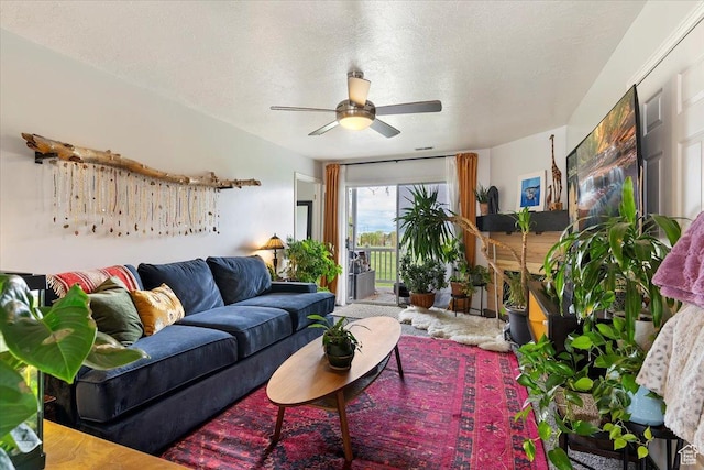 living area with a textured ceiling and ceiling fan