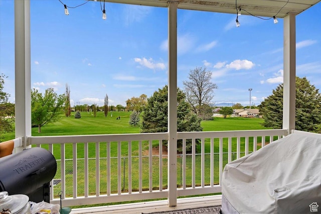 deck with area for grilling, a lawn, and view of golf course