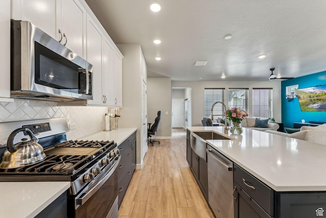 11619 S Silver Pond Dr W, South Jordan, UT 84009 - kitchen featuring a sink, light countertops, white cabinets, open floor plan, and stainless steel appliances