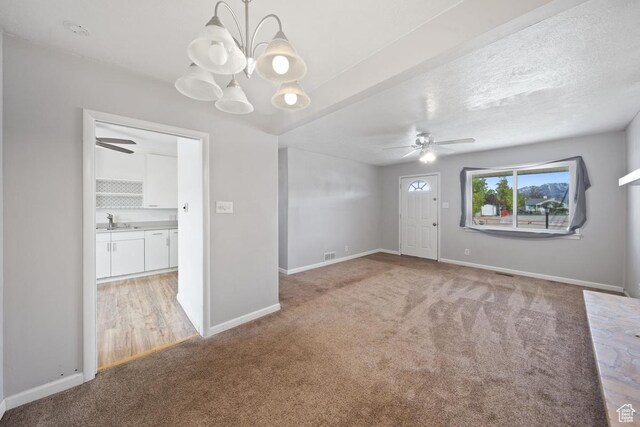 5390 S 4460 W, Kearns, UT 84118 - unfurnished room featuring light carpet, a sink, ceiling fan with notable chandelier, baseboards, and visible vents