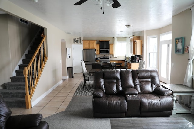 7044 W 8050 S, West Jordan, UT 84081 - living area with ceiling fan, arched walkways, baseboards, light tile patterned floors, and stairway