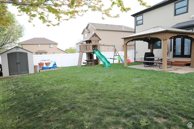 7044 W 8050 S, West Jordan, UT 84081 - view of yard with a storage shed, a patio area, a gazebo, a fenced backyard, and a playground