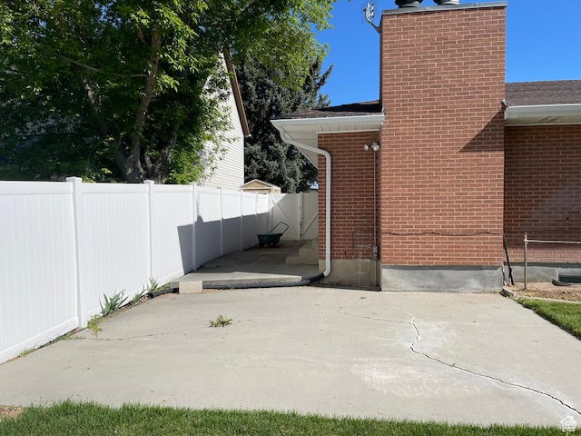 1846 E 9800 S, Sandy, UT 84092 - view of side of home with brick siding, a patio area, fence, and a chimney