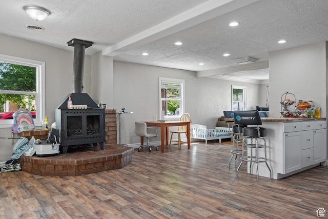 4207 W 5655 S, Salt Lake City, UT 84118 - living room with dark wood-style flooring, a textured ceiling, visible vents, and a wood stove