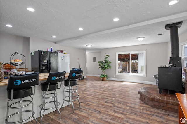 4207 W 5655 S, Salt Lake City, UT 84118 - kitchen with a textured ceiling, black refrigerator with ice dispenser, wood finished floors, and a wood stove