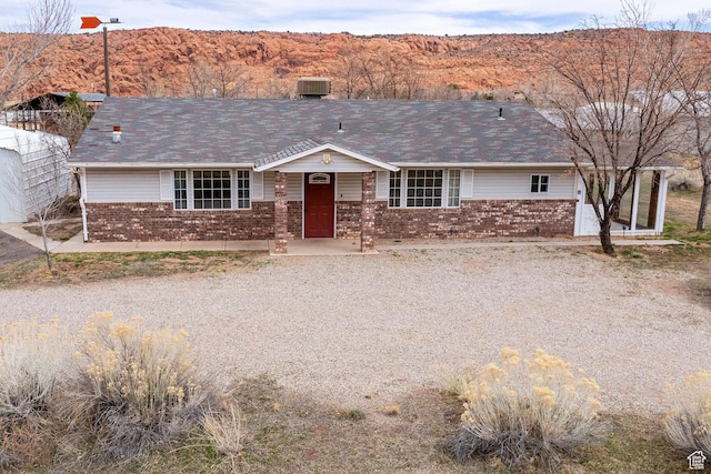 3971 S Spanish Valley Dr, Moab, UT 84532 - ranch-style home with roof with shingles, a mountain view, central AC, and brick siding