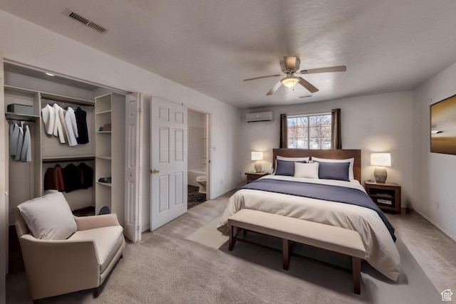3971 S Spanish Valley Dr, Moab, UT 84532 - carpeted bedroom featuring a ceiling fan, visible vents, a wall mounted air conditioner, a closet, and ensuite bath