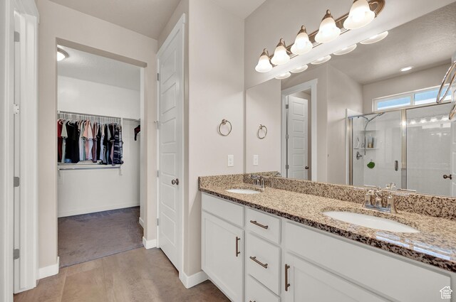 2770 S Sinbad Way W, Magna, UT 84044 - bathroom with double vanity, a sink, a walk in closet, and a stall shower
