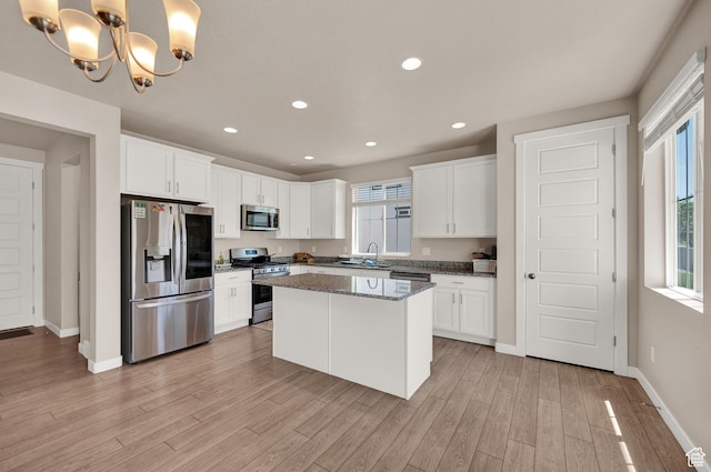 2770 S Sinbad Way W, Magna, UT 84044 - kitchen featuring baseboards, white cabinetry, a sink, light wood finished floors, and stainless steel appliances