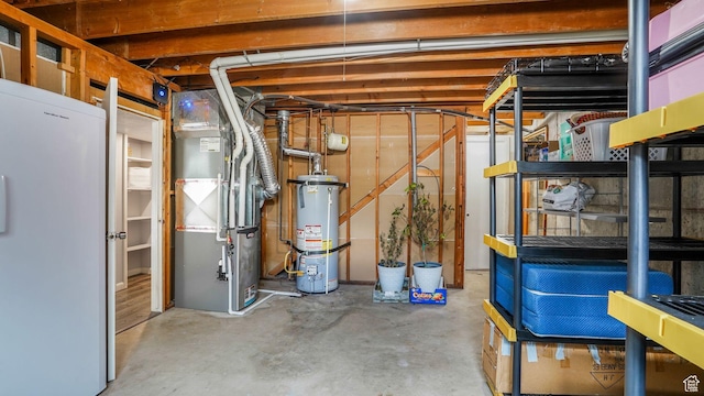 875 E 1150 S Unit 21, Ogden, UT 84404 - unfinished basement with heating unit, strapped water heater, and freestanding refrigerator
