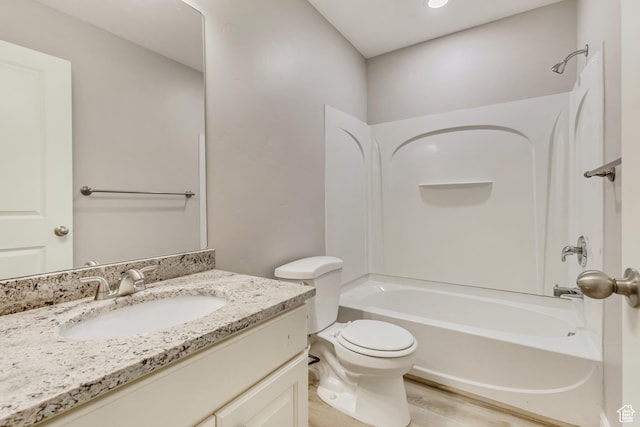 full bathroom featuring wood finished floors, bathtub / shower combination, toilet, and vanity