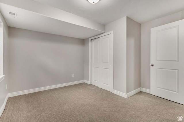 unfurnished bedroom with baseboards, visible vents, and carpet