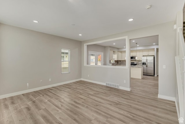 unfurnished living room with recessed lighting, baseboards, visible vents, and light wood-style floors