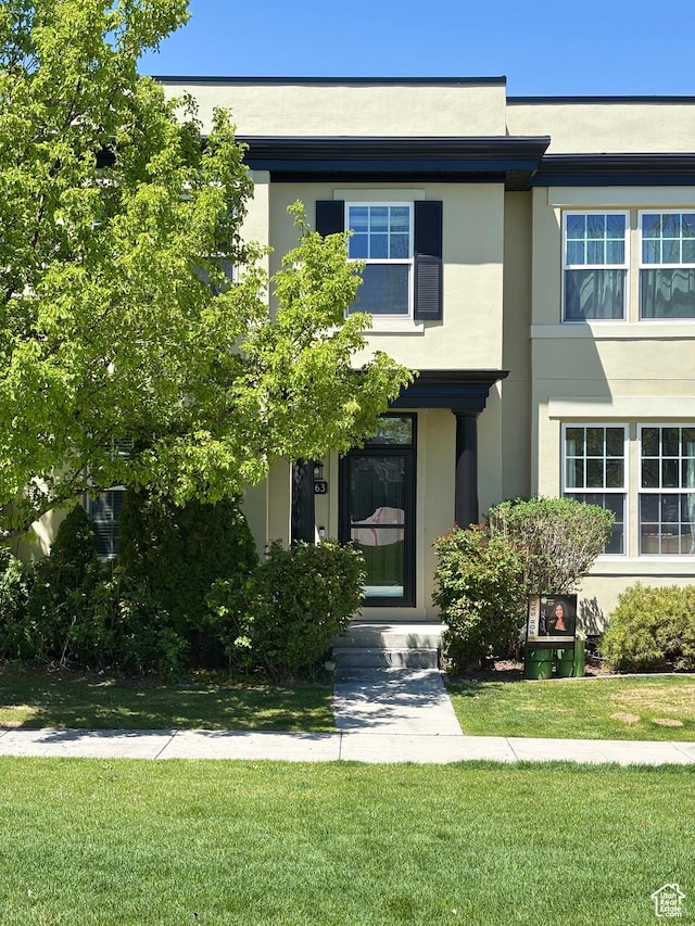 view of front of property with a front yard and stucco siding