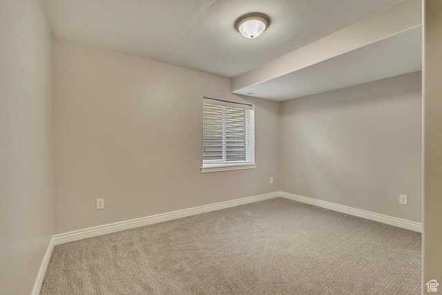 spare room featuring carpet flooring and baseboards