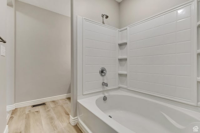 full bathroom featuring shower / bath combination, baseboards, wood finished floors, and visible vents