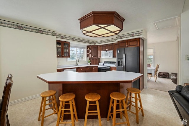 4851 E Lake Creek Rd, Heber City, UT 84032 - kitchen with glass insert cabinets, white microwave, a kitchen bar, light countertops, and electric range oven