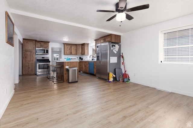 463 E Main St, Salina, UT 84654 - kitchen featuring a kitchen island, a kitchen breakfast bar, light countertops, a ceiling fan, and appliances with stainless steel finishes