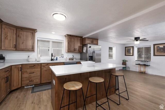 463 E Main St, Salina, UT 84654 - kitchen with a textured ceiling, light countertops, light wood finished floors, stainless steel fridge, and a breakfast bar