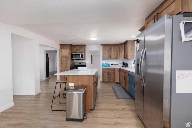 463 E Main St, Salina, UT 84654 - kitchen with light wood-style floors, appliances with stainless steel finishes, a kitchen breakfast bar, and a center island