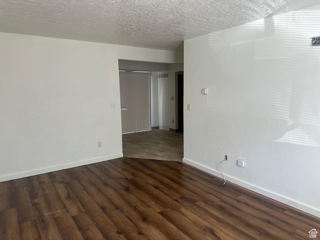 558 N Redwood Rd Unit 2-4, Salt Lake City, UT 84116 - empty room featuring dark wood-style flooring, baseboards, visible vents, and a textured ceiling