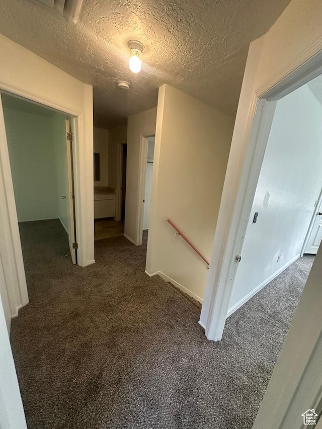 558 N Redwood Rd Unit 2-4, Salt Lake City, UT 84116 - hall with dark colored carpet, a textured ceiling, and an upstairs landing