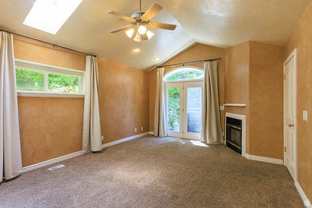 724 E 3230 N, Provo, UT 84604 - unfurnished living room with vaulted ceiling with skylight, ceiling fan, visible vents, a glass covered fireplace, and carpet flooring