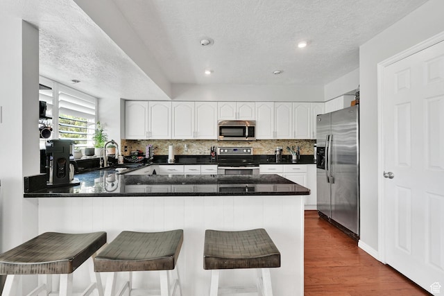 267 W 1600 N, Layton, UT 84041 - kitchen featuring appliances with stainless steel finishes, tasteful backsplash, a peninsula, and a textured ceiling