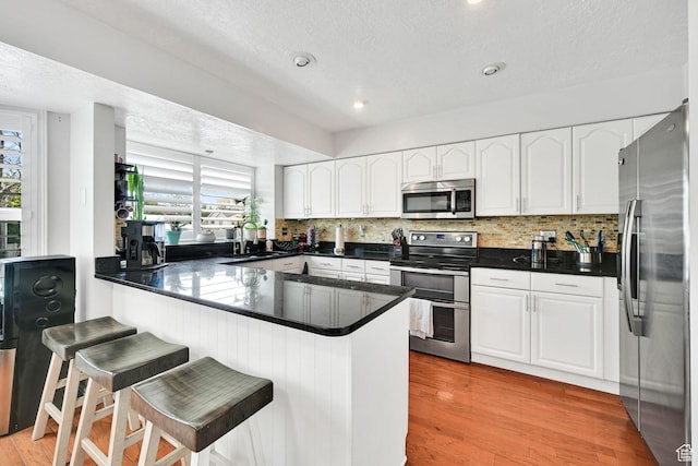267 W 1600 N, Layton, UT 84041 - kitchen featuring stainless steel appliances, a textured ceiling, white cabinetry, and a peninsula