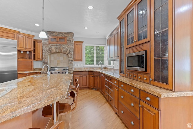 359 E 680 N, Lindon, UT 84042 - kitchen featuring built in appliances, a sink, a kitchen breakfast bar, light wood-type flooring, and crown molding