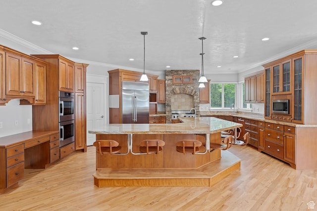 359 E 680 N, Lindon, UT 84042 - kitchen featuring built in appliances, crown molding, brown cabinetry, a large island with sink, and light wood finished floors