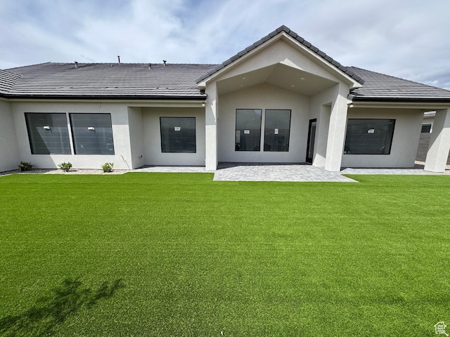 5269 W 2040 S, Hurricane, UT 84737 - rear view of house featuring a lawn, a patio, stucco siding, and a tiled roof