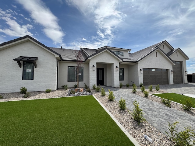 5269 W 2040 S, Hurricane, UT 84737 - view of front of home featuring brick siding, an attached garage, decorative driveway, and a front yard