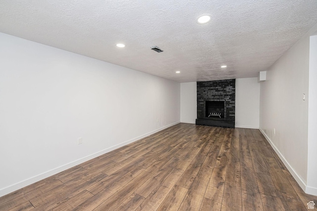 4432 Orchard Ave, South Ogden, UT 84403 - unfurnished living room featuring dark wood-style flooring, a fireplace, baseboards, recessed lighting, and a textured ceiling