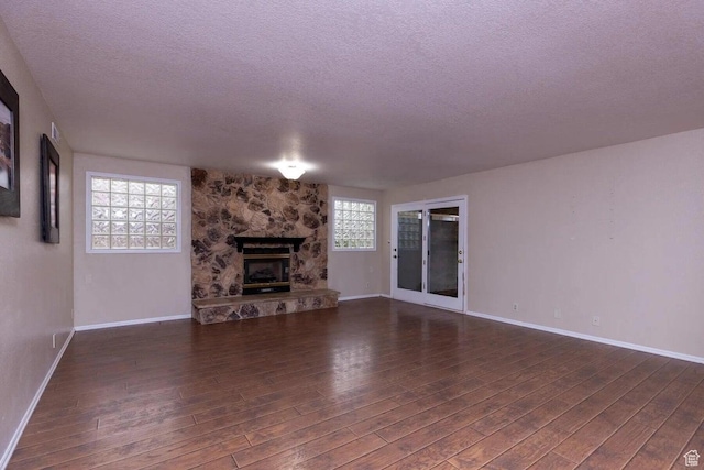 623 E 160 S, St George, UT 84770 - unfurnished living room featuring baseboards, a fireplace, a textured ceiling, and dark wood-type flooring