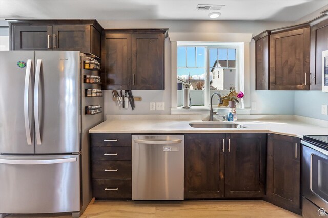 1150 W 200 S, Logan, UT 84321 - kitchen with visible vents, dark brown cabinets, light countertops, a sink, and appliances with stainless steel finishes