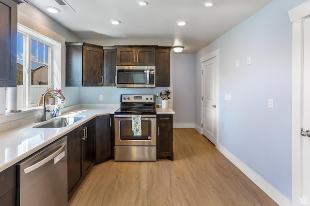 1150 W 200 S, Logan, UT 84321 - kitchen featuring dark brown cabinets, a sink, stainless steel appliances, recessed lighting, and light wood-style flooring