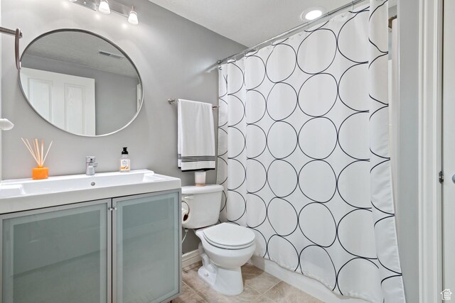 full bath featuring a shower with curtain, visible vents, vanity, tile patterned floors, and toilet