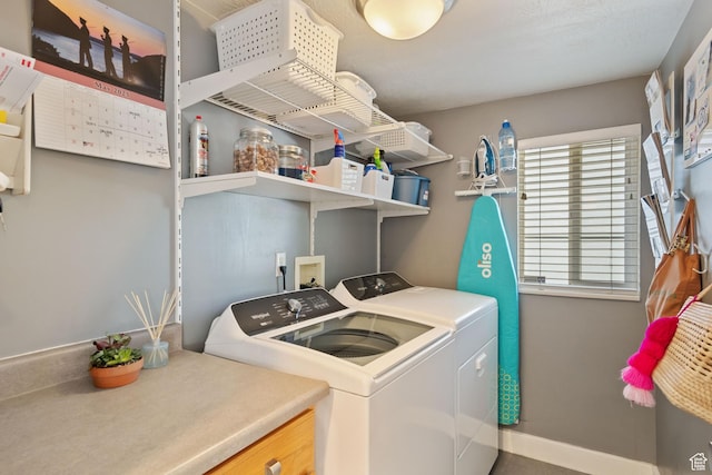 laundry area with washing machine and clothes dryer, laundry area, and baseboards