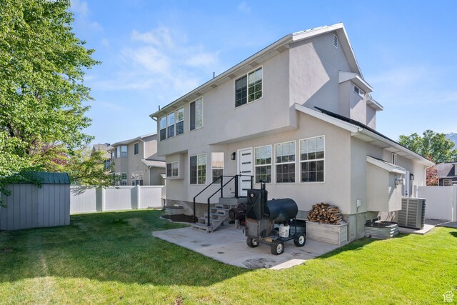rear view of house featuring an outdoor structure, fence, stucco siding, a shed, and a yard