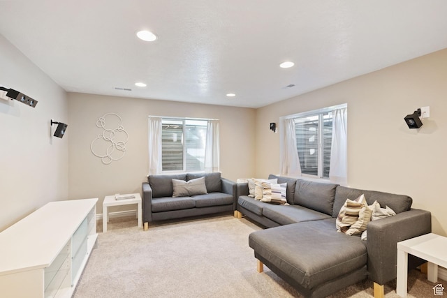 living area featuring recessed lighting, baseboards, visible vents, and light carpet