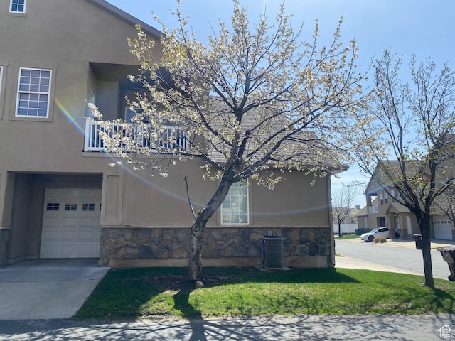 948 Shetland Ln Unit 17, Farmington, UT 84025 - view of property exterior with stone siding, a garage, cooling unit, stucco siding, and a balcony