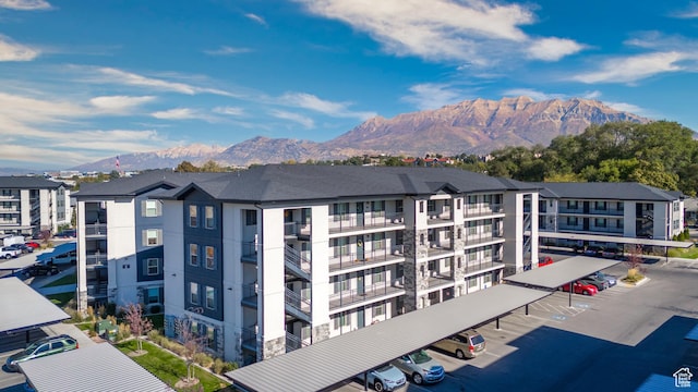 view of property with covered parking and a mountain view