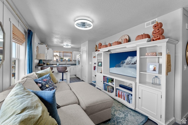 1700 S Sandhill Rd S Unit F301, Orem, UT 84058 - living room featuring a textured ceiling and visible vents
