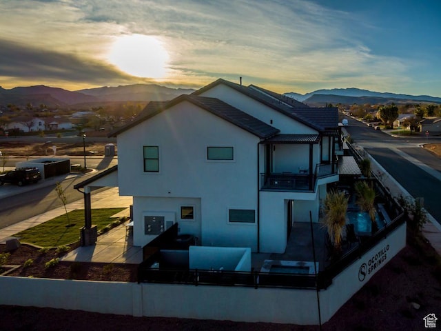 2600 Ocotillo Way Unit 31, Santa Clara, UT 84765 - back of house at dusk featuring a mountain view, a patio, a balcony, and stucco siding