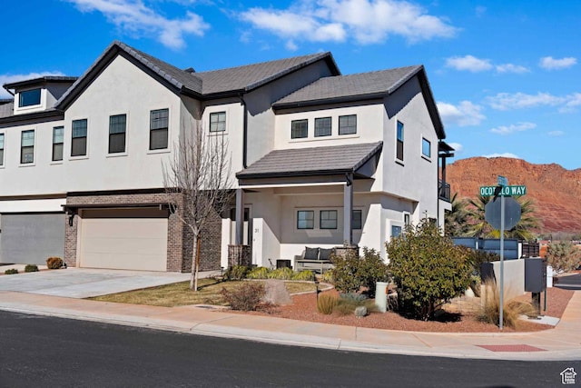 2600 Ocotillo Way Unit 31, Santa Clara, UT 84765 - view of front of property featuring a garage, concrete driveway, stucco siding, a mountain view, and brick siding