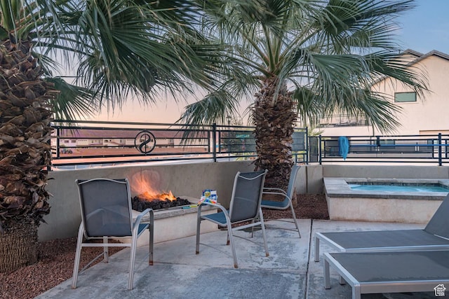 2600 Ocotillo Way Unit 31, Santa Clara, UT 84765 - patio terrace at dusk with an in-ground hot tub, a fire pit, and fence
